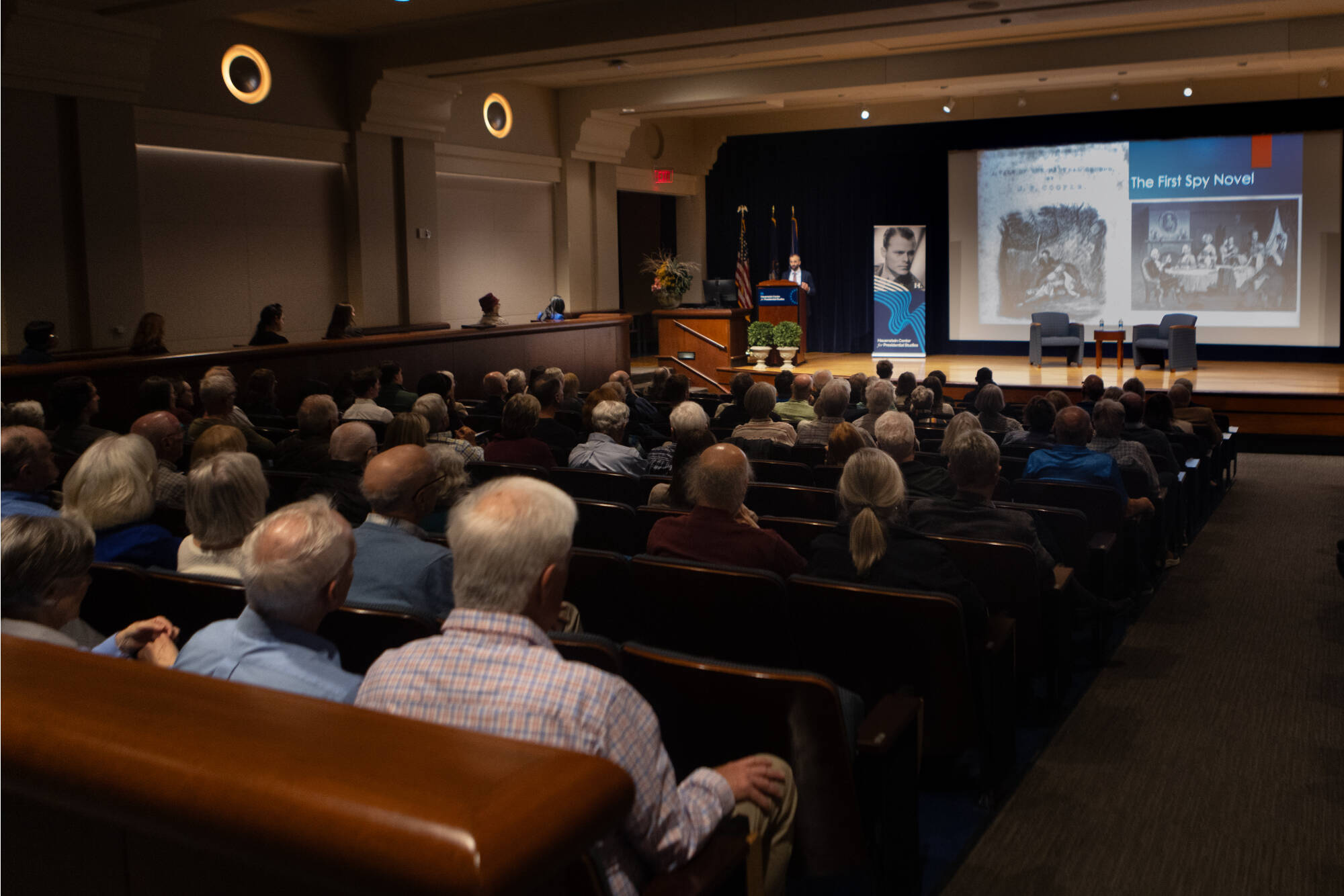 A crowd sits in Loosemore Auditorium viewing a Hauenstein Center event taking place on stage.